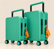 Two hard-shell spinner suitcases in a bright mint green color, one small and one large, with black telescoping handles and orange luggage tags, set against a solid light beige background.