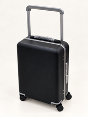 A black hard-shell carry-on suitcase with a silver telescoping handle and four spinner wheels, shown on a clean white background.