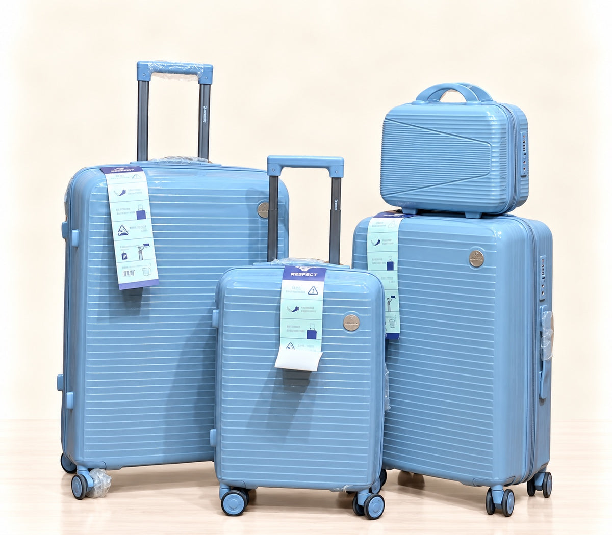 A three-piece pink luggage set consisting of a large spinner suitcase, a medium spinner suitcase, and a matching small handbag, all with telescoping handles and wheels, shown on a light beige background. 